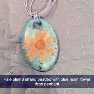 Resin flower pendant with 3 strand beaded necklace in light blue.